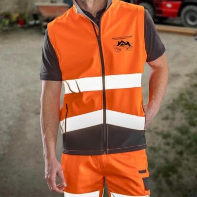 Veste haute visibilité orange et noire, personnalisée avec le logo Provence Toiture, portée par un professionnel du bâtiment.