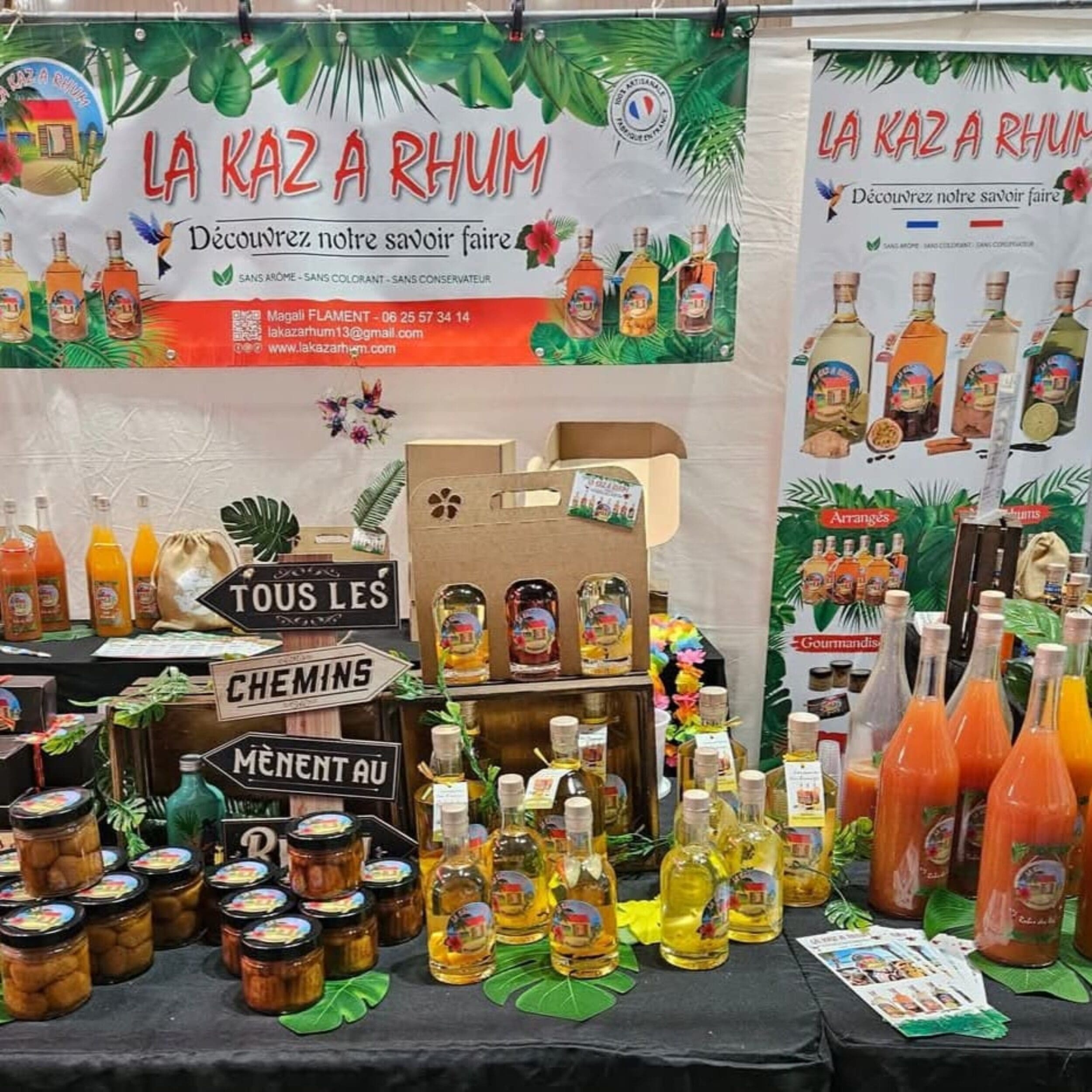 Stand coloré de La Kaz à Rhum présentant bâches, roll-up, calendriers, cartes de visite et flyers personnalisés lors d’un salon.