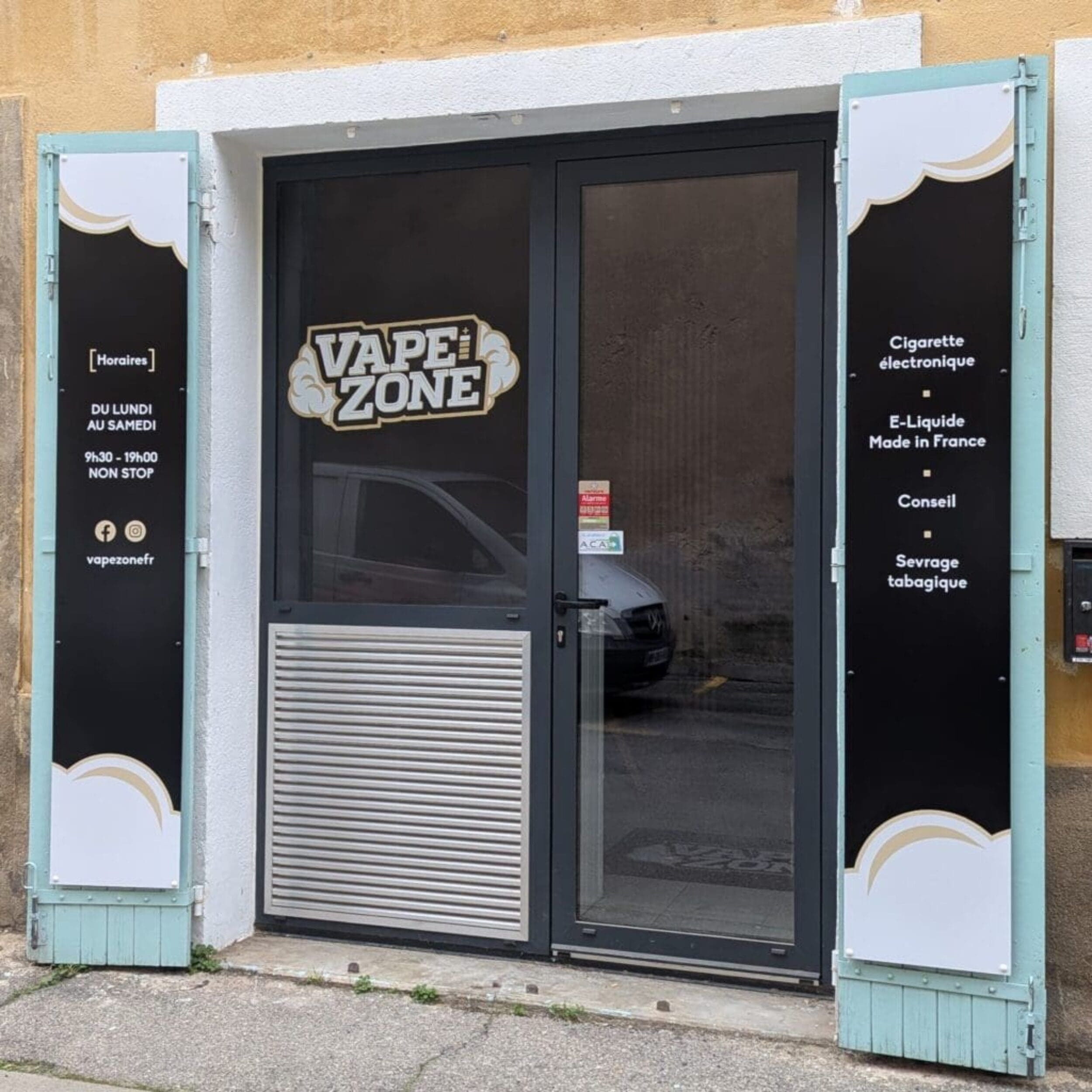 Façade de la boutique Vape Zone avec vitrophanie noire et dorée, affichant le logo, les horaires et les services proposés.