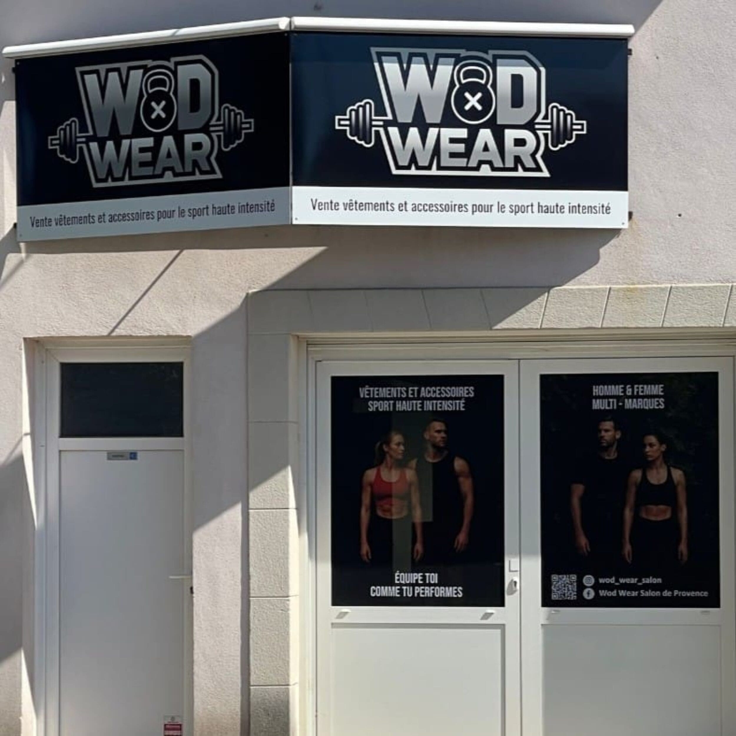 Façade de boutique avec enseigne "WOD WEAR" et affiches de vêtements de sport haute intensité.