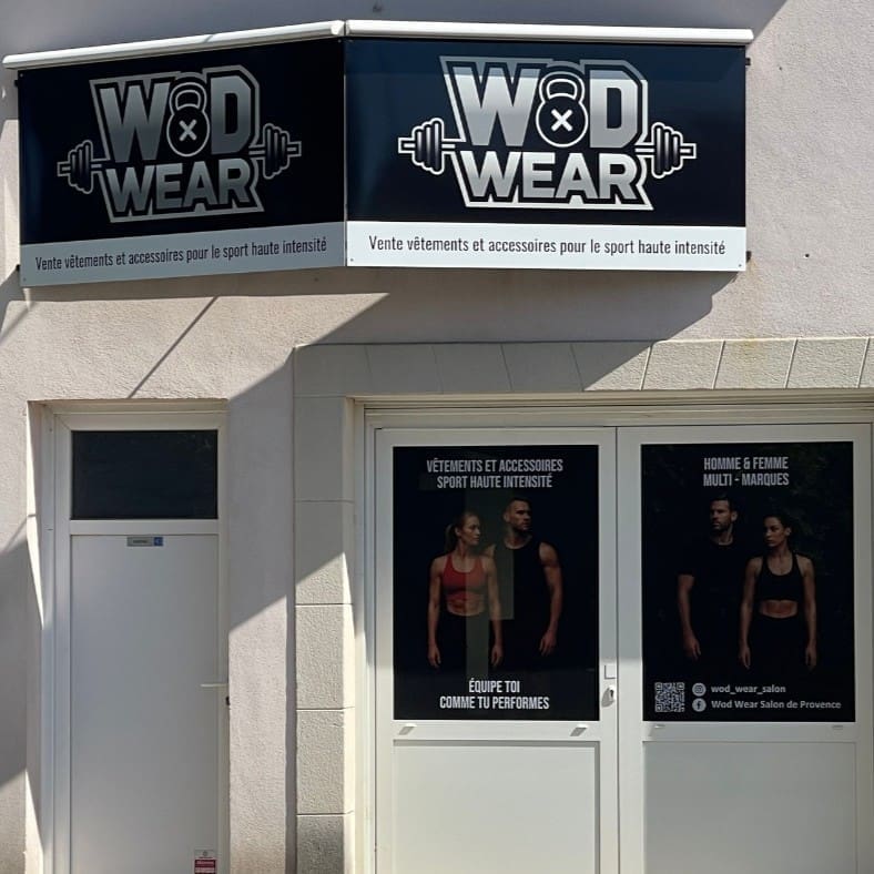 Façade de boutique avec enseigne "WOD WEAR" et affiches de vêtements de sport haute intensité.